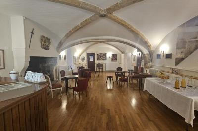 Des personnes en costumes d'époque discutent dans la cour d'un château historique sous un ciel partiellement nuageux.