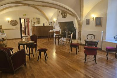 Des personnes en costumes d'époque discutent dans la cour d'un château historique sous un ciel partiellement nuageux.