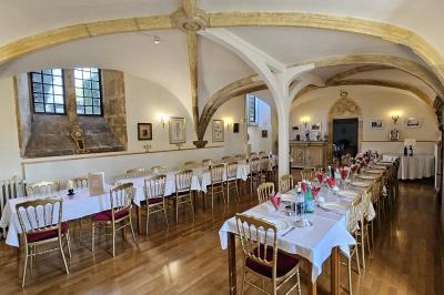 Des personnes en costumes d'époque discutent dans la cour d'un château historique sous un ciel partiellement nuageux.
