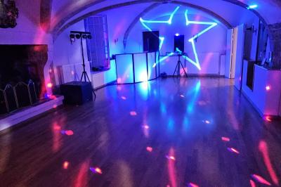 Des personnes en costumes d'époque discutent dans la cour d'un château historique sous un ciel partiellement nuageux.