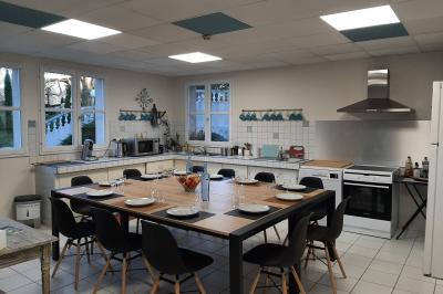 Des personnes en costumes d'époque discutent dans la cour d'un château historique sous un ciel partiellement nuageux.