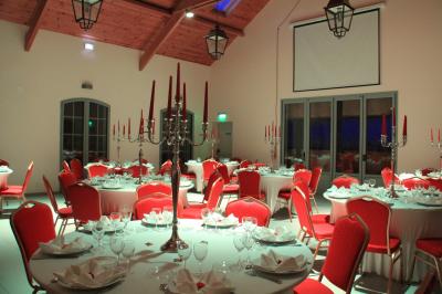 Piscine extérieure avec terrasse en pierre, cabane en bois et arbres en arrière-plan par une journée ensoleillée.