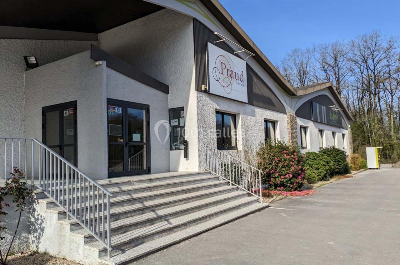 Façade d'un bâtiment commercial avec une entrée principale accessible par des escaliers et des rampes.