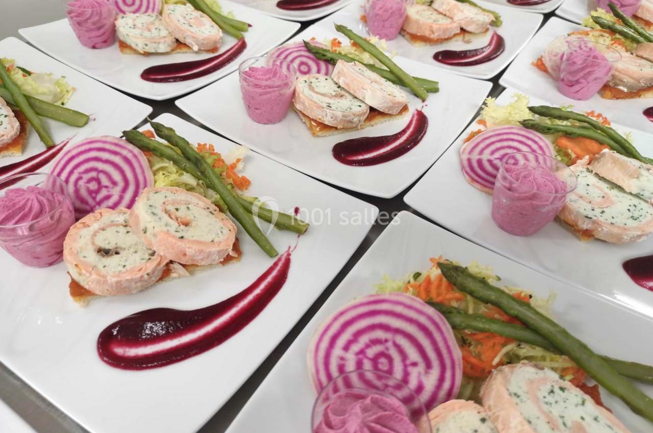 Assiettes dressées avec roulés de saumon, purée rose, betterave, asperges et sauce rouge sur lit de légumes.