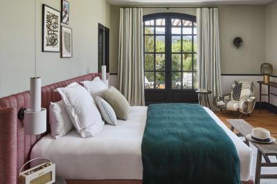 Terrains de padel extérieurs entourés d'arbres et éclairés par des lampadaires, avec un chemin en premier plan.