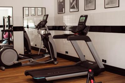 Terrains de padel extérieurs entourés d'arbres et éclairés par des lampadaires, avec un chemin en premier plan.