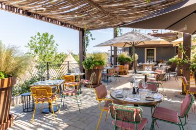 Terrains de padel extérieurs entourés d'arbres et éclairés par des lampadaires, avec un chemin en premier plan.