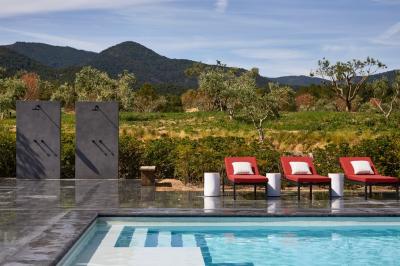 Terrains de padel extérieurs entourés d'arbres et éclairés par des lampadaires, avec un chemin en premier plan.