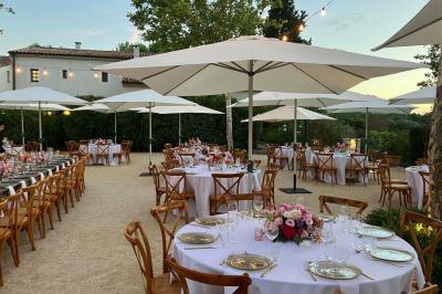 Terrains de padel extérieurs entourés d'arbres et éclairés par des lampadaires, avec un chemin en premier plan.