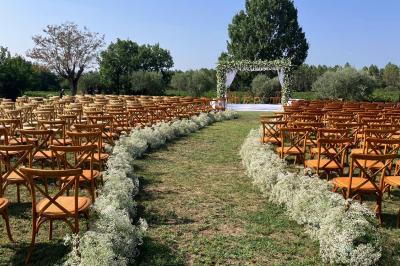 Terrains de padel extérieurs entourés d'arbres et éclairés par des lampadaires, avec un chemin en premier plan.