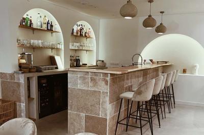 Façade d'un établissement avec vitrines décorées, porte ouverte et panneaux d'information sur le trottoir.