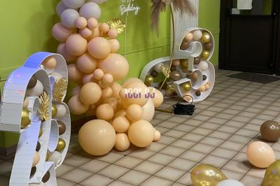 Un DJ souriant derrière une table équipée de matériel audio, avec un ordinateur portable et une table de mixage.