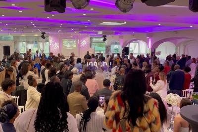 Un DJ souriant derrière une table de mixage avec un ordinateur portable et des équipements audio.