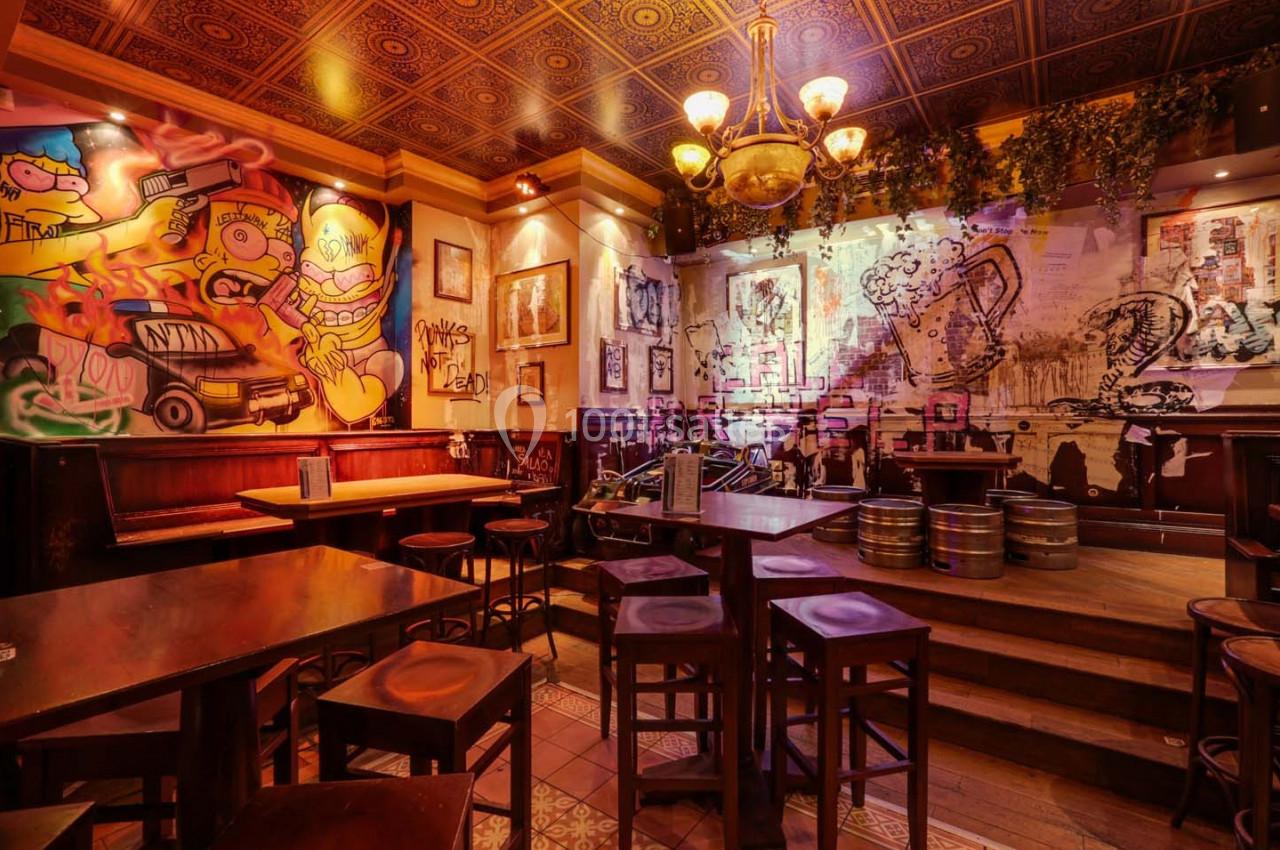 Salle de restaurant avec murs décorés de graffitis colorés, mobilier en bois et ambiance chaleureuse.