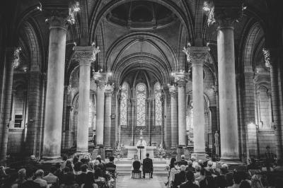 Des personnes en tenue élégante regardent des danseuses en maillot de bain et bonnet, lors d'un événement en extérieur.