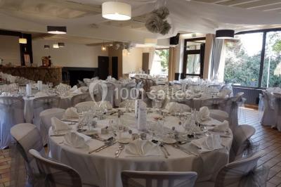 Étang calme entouré d'arbres avec un paysage vallonné en arrière-plan sous une lumière naturelle.
