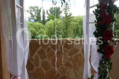 Étang calme entouré d'arbres avec un paysage vallonné en arrière-plan sous une lumière naturelle.