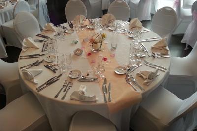 Étang calme entouré d'arbres avec un paysage vallonné en arrière-plan sous une lumière naturelle.