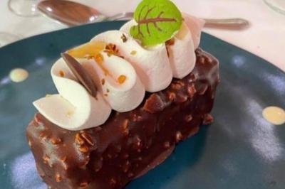 Étang calme entouré d'arbres avec un paysage vallonné en arrière-plan sous une lumière naturelle.