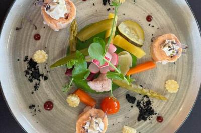 Étang calme entouré d'arbres avec un paysage vallonné en arrière-plan sous une lumière naturelle.