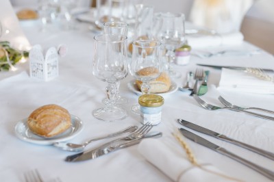 Étang calme entouré d'arbres avec un paysage vallonné en arrière-plan sous une lumière naturelle.