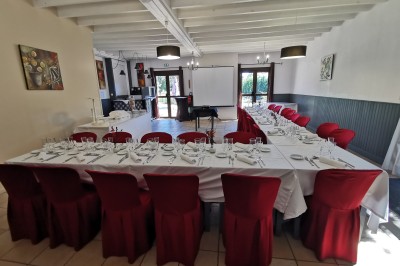 Étang calme entouré d'arbres avec un paysage vallonné en arrière-plan sous une lumière naturelle.