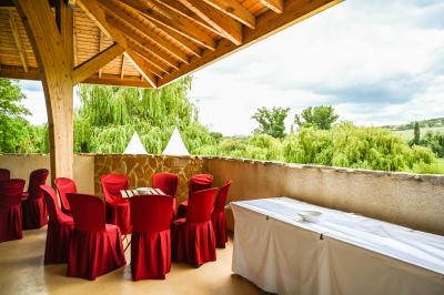 Salle de réception aménagée avec des tables dressées pour un événement, éclairage tamisé et scène en arrière-plan.