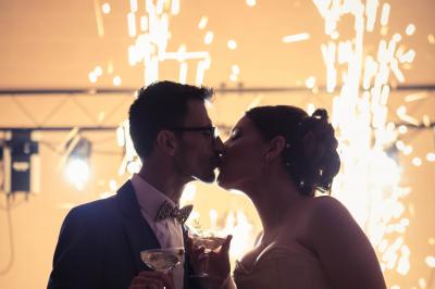 Corset blanc en dentelle et satin éclairé par des lumières vertes et violettes dans un environnement sombre.