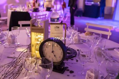 Corset blanc en satin et dentelle, éclairé par des lumières colorées dans un environnement sombre.