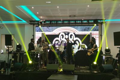 Un DJ portant un casque audio mixe sur son équipement dans un environnement sombre.