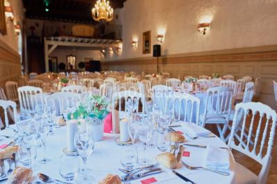 Deux portes en pierre et bois s'ouvrent sur des pièces lumineuses avec mobilier classique et parquet.
