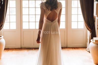 Deux portes en pierre et bois s'ouvrent sur des pièces lumineuses avec mobilier classique et parquet.