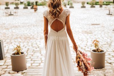 Deux portes en pierre et bois s'ouvrent sur des pièces lumineuses avec mobilier classique et parquet.