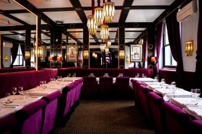 Cocktail jaune orangé garni d’un demi-fruit de la passion, accompagné d’un verre de champagne sur un comptoir en bois.