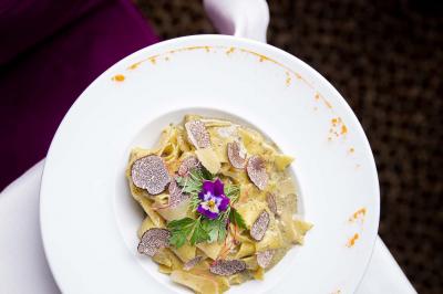 Cocktail jaune orangé garni d’un demi-fruit de la passion, accompagné d’un verre de champagne sur un comptoir en bois.