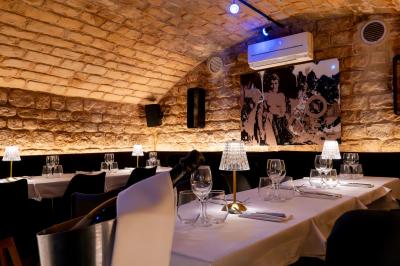 Cocktail jaune orangé garni d’un demi-fruit de la passion, accompagné d’un verre de champagne sur un comptoir en bois.