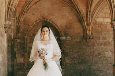 Un couple s'embrasse en arrière-plan tandis qu'un bouquet de fleurs est mis au premier plan.