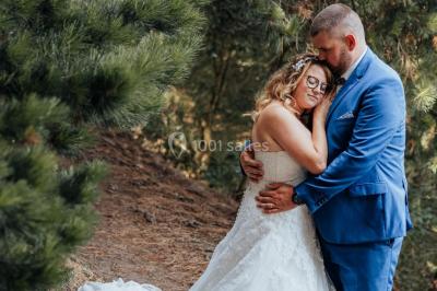Un couple s'embrasse en arrière-plan tandis qu'un bouquet de fleurs est mis au premier plan.