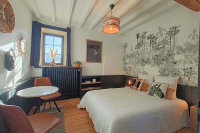 Vue d'un petit cours d'eau bordé de végétation luxuriante sous un ciel partiellement nuageux.