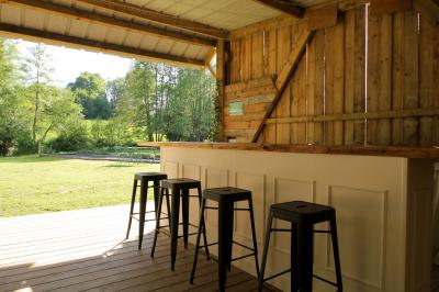 Vue d'un petit cours d'eau bordé de végétation luxuriante sous un ciel partiellement nuageux.