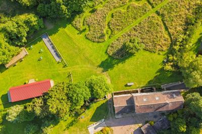 Vue d'un petit cours d'eau bordé de végétation luxuriante sous un ciel partiellement nuageux.