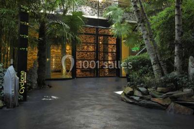 Salle lumineuse avec parquet, mobilier moderne, œuvres d'art au mur et grandes fenêtres laissant entrer la lumière naturelle.