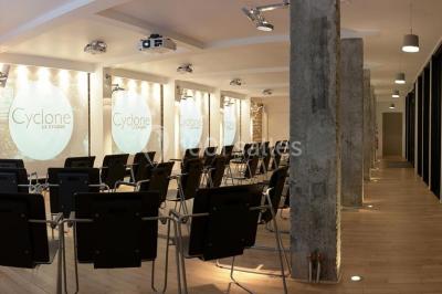 Salle lumineuse avec parquet, mobilier moderne, œuvres d'art au mur et grandes fenêtres laissant entrer la lumière naturelle.