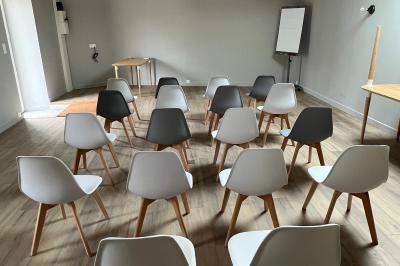 Cabane en forme de A éclairée de l'intérieur, entourée d'arbres dans un environnement nocturne.