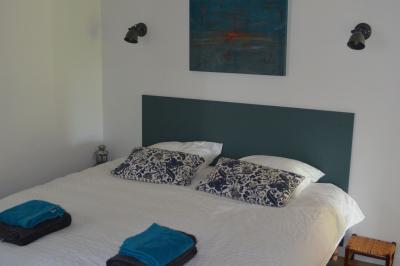 Cabane en forme de A éclairée de l'intérieur, entourée d'arbres dans un environnement nocturne.