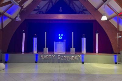 Un couple danse dans une ambiance festive avec éclairages colorés, fumée et étincelles décoratives.