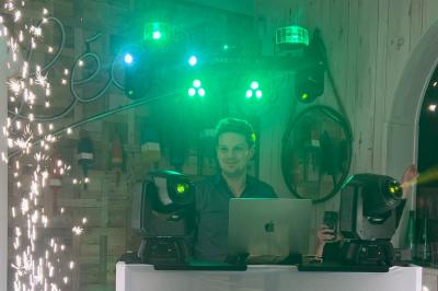 Un couple danse dans une ambiance festive avec éclairages colorés, fumée et étincelles décoratives.