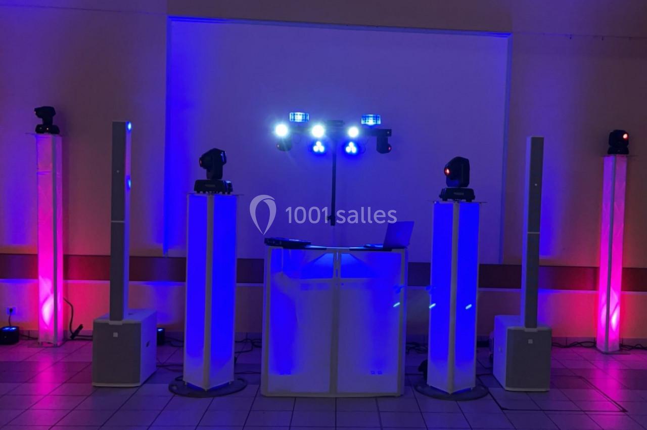 Équipement de sonorisation et éclairage avec lumières colorées installé dans une salle pour un événement.