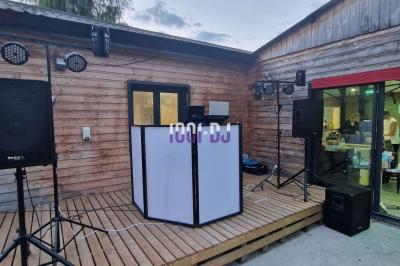 Installation de matériel de sonorisation et éclairage coloré dans une salle avec un fond de mur rouge.