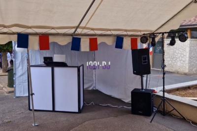 Installation de matériel de sonorisation et éclairage coloré dans une salle avec un fond de mur rouge.